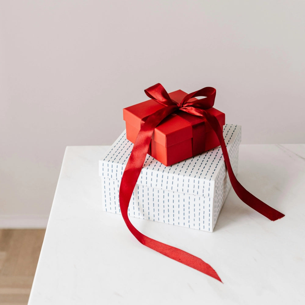 zwei Geschenkkarton mit roter Schleife 