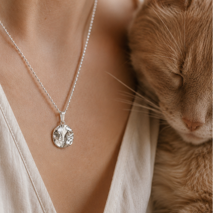 Anhänger mit dem originalen Abdruck einer Katzennase, liegend am hals einer Frau, die mit ihrer Katze kuschelt